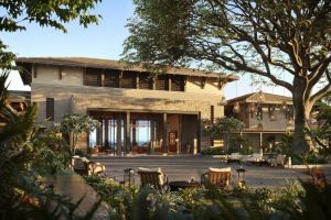 A two-story home surrounding by tropical foliage